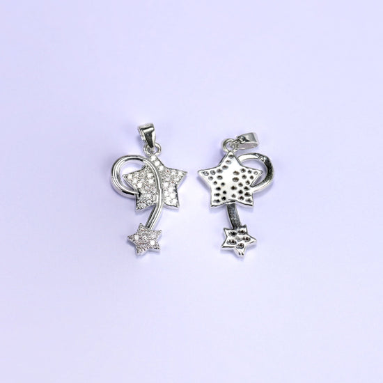 Wishing star zirconia charms in silver tone, one shooting star pendant face up with clear pave and one flipped to the plain reverse.