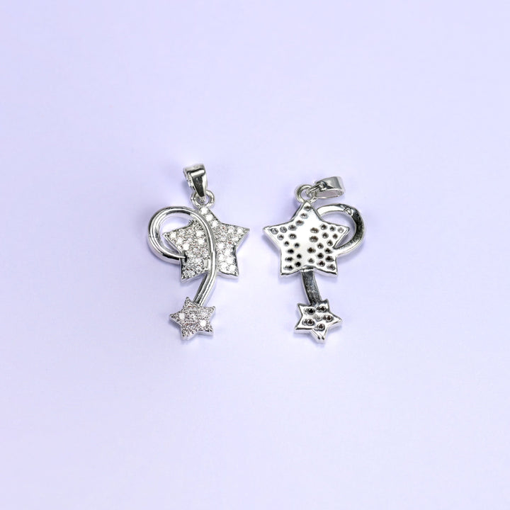 Wishing star zirconia charms in silver tone, one shooting star pendant face up with clear pave and one flipped to the plain reverse.