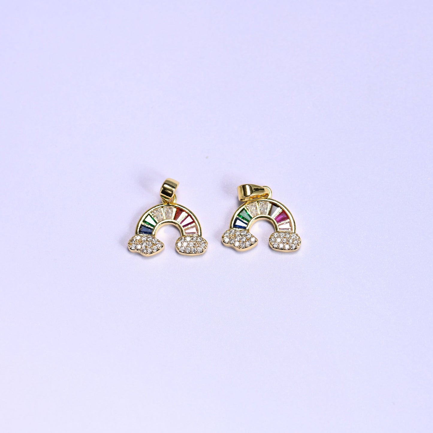 Two gold Rainbow Zirconia Charms side by side, 18K gold plated arcs of multicolor baguette zirconia resting on pave zirconia clouds.