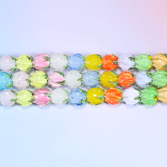 Close-up rows of pastel tulip bud lampwork glass beads in blue, white, yellow, and pink tones, laid in a dense repeating pattern.