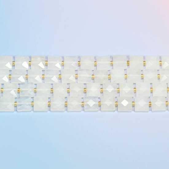 Several strands of clear quartz faceted flat square beads laid in straight rows