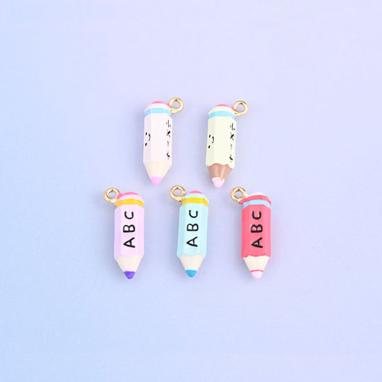 Five pencil charms, light purple, light blue and pink in front with two light green behind.