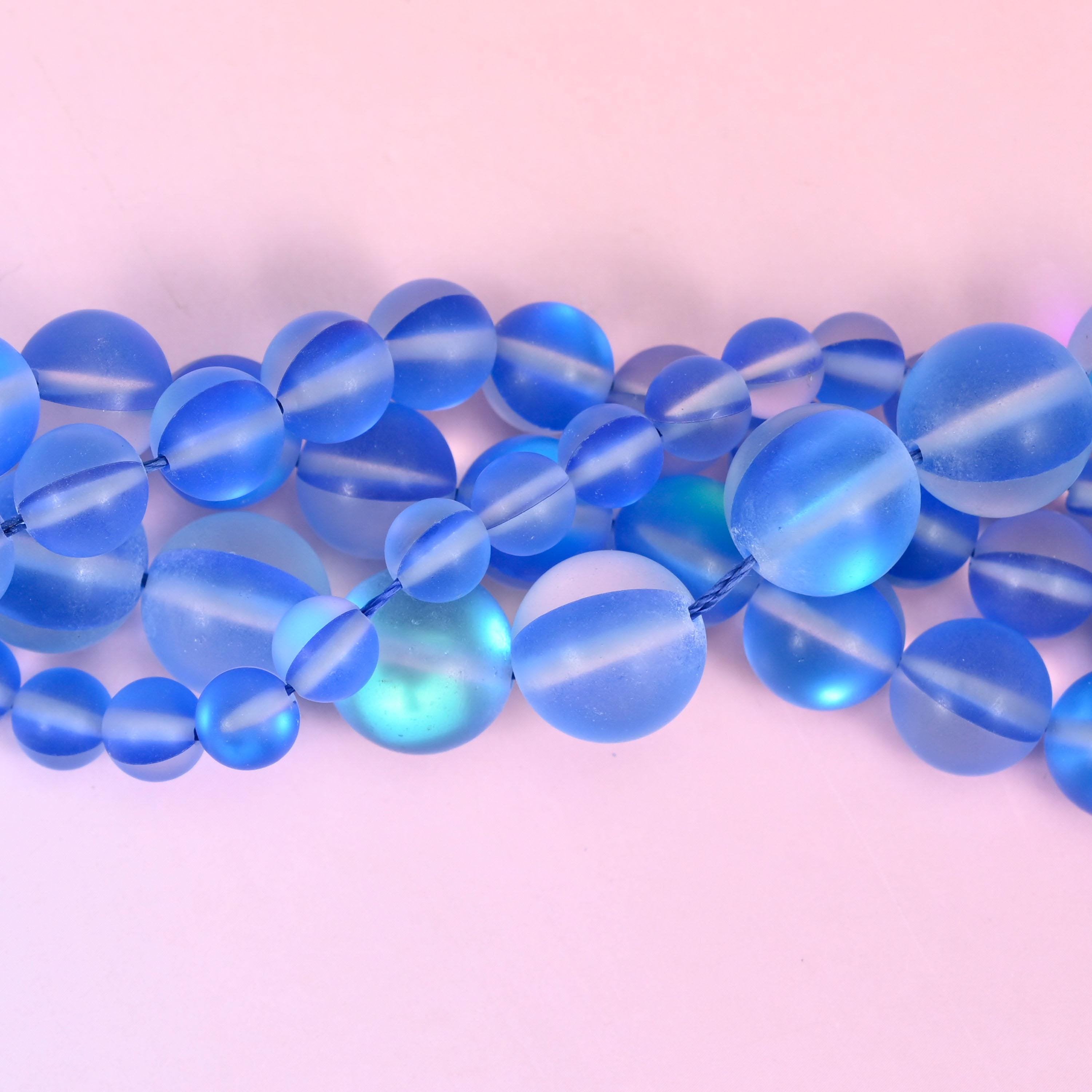 Cornflower blue glass rounds with a sanded frosted finish and an iridescent coating that reads as an inner light