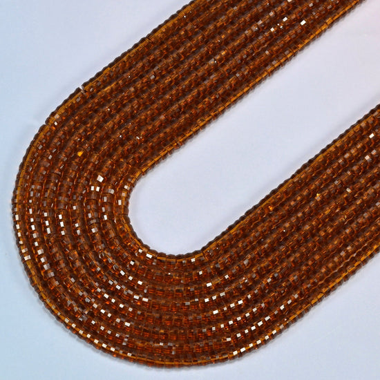 Brown glass faceted heishi disc beads in several strands curved into a wide U, transparent amber brown glass