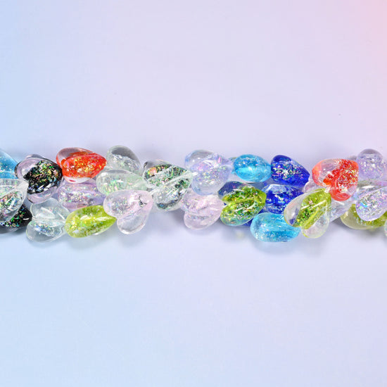 Puffed transparent hearts in a mixed run of clear, ice blue, cobalt, lime, coral red and speckled black with an iridescent coating