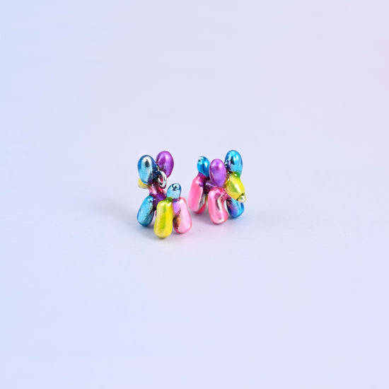 Two balloon dog charms side by side, showing the round balloon head and ears in metallic purple and blue.