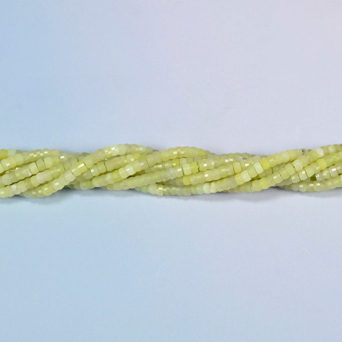 Strands of Lemon Jade faceted heishi disc beads twisted together in a horizontal row