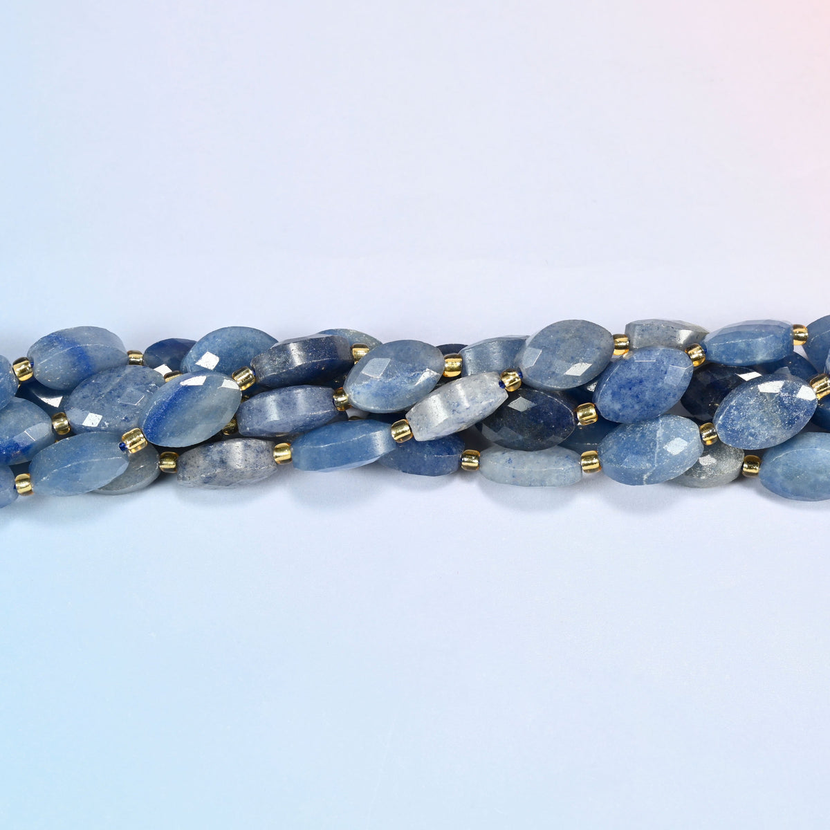 Strands of blue aventurine faceted flat oval beads twisted together in a horizontal row