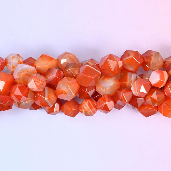 Dyed Red Stripe Agate faceted beads close up in a single row, flat triangular star cut planes over brick red and white stripes