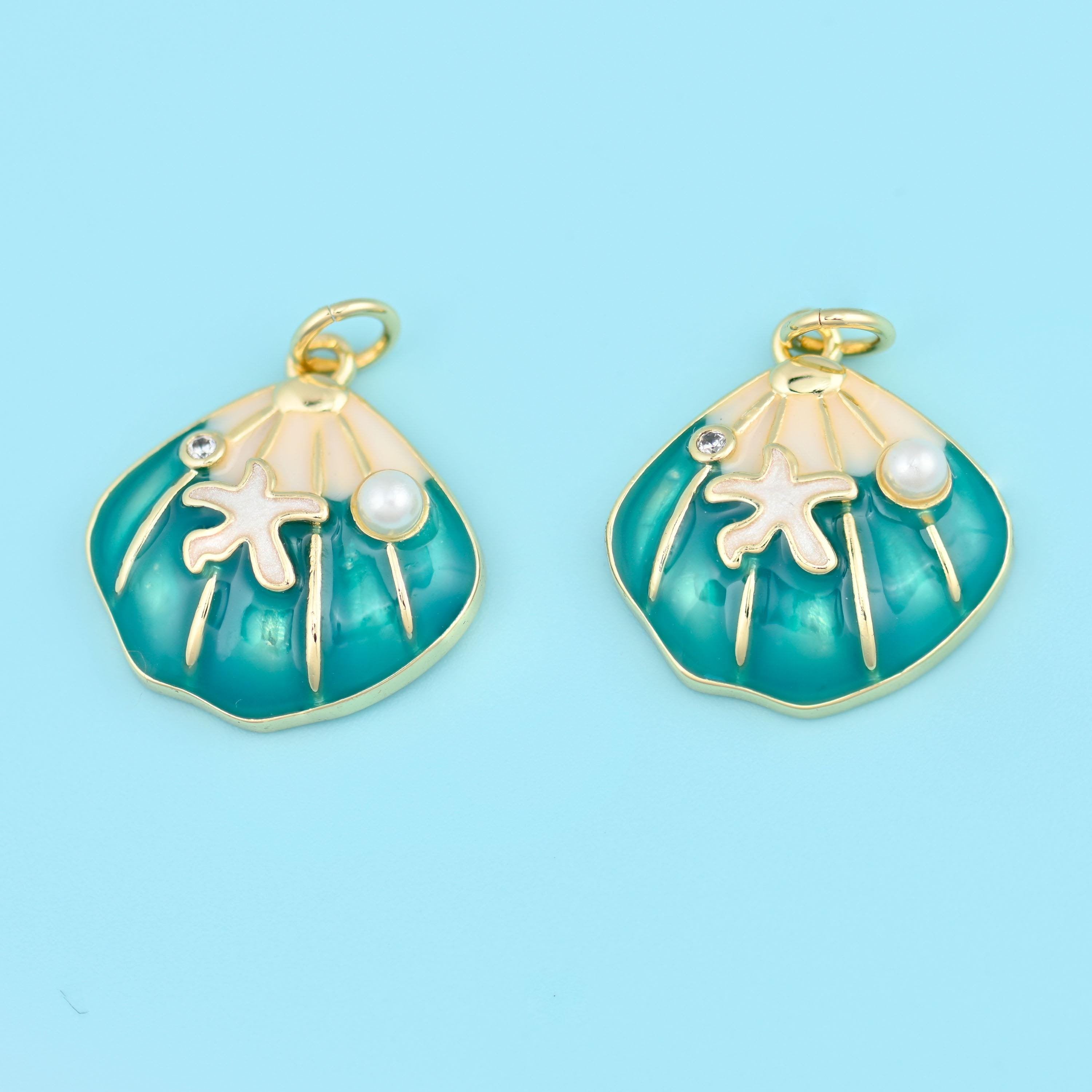 A gold-ribbed scallop shell flooded with glossy enamel, with a cream starfish and a small pearl bead set across the hinge…