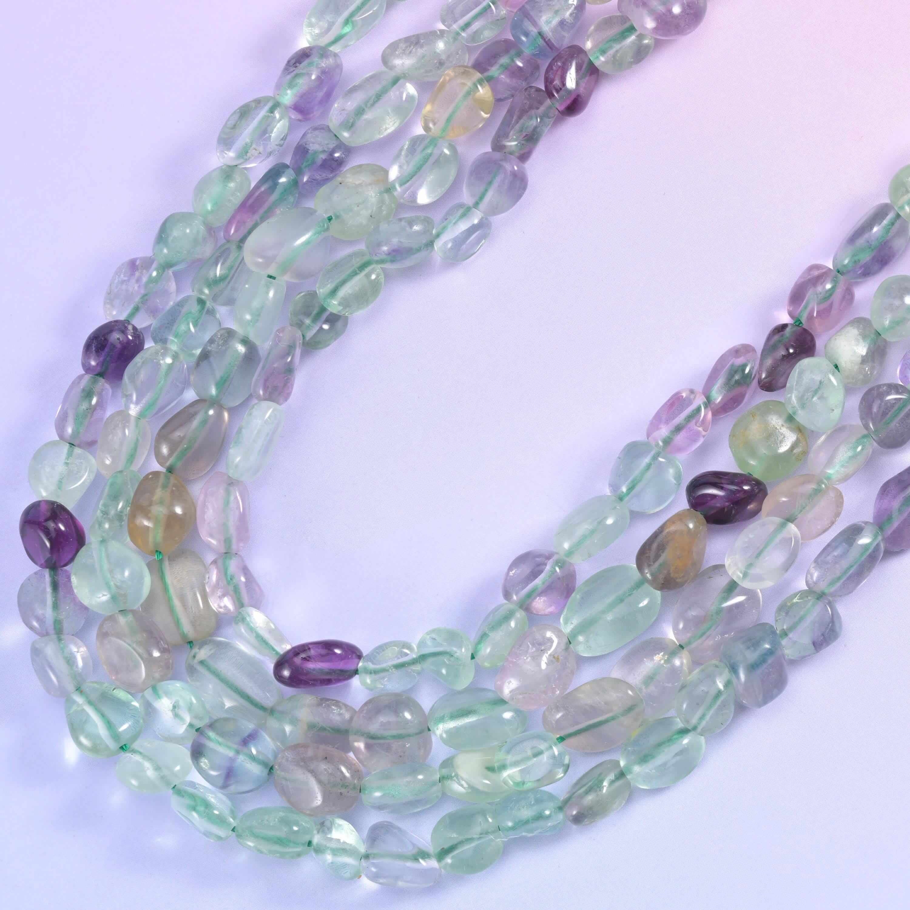 Two fluorite nugget strands curving in a U shape, tumbled and glassy