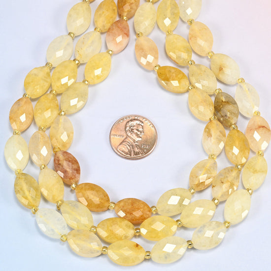 Golden healer quartz faceted flat oval strands formed into a teardrop loop around a US penny for scale