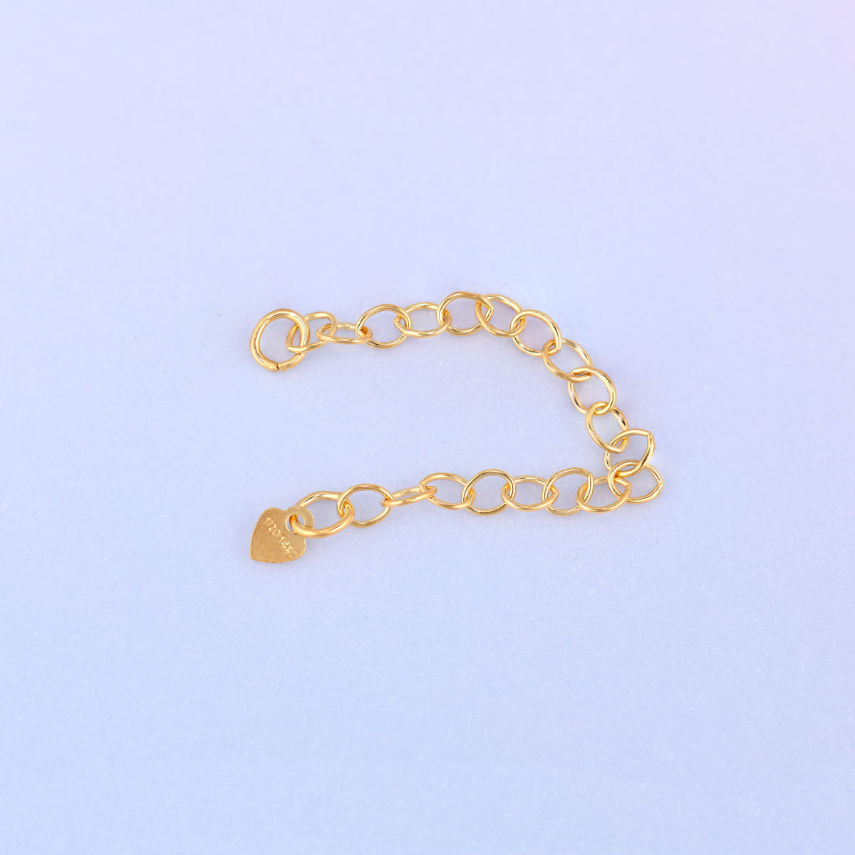14K gold filled heart chain extender curved gently, showing the heart charm stamped 1/20 14K near the jump ring end.