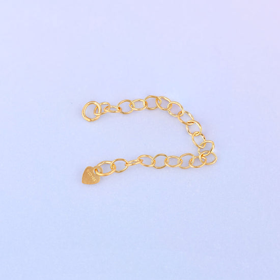 14K gold filled heart chain extender curved gently, showing the heart charm stamped 1/20 14K near the jump ring end.