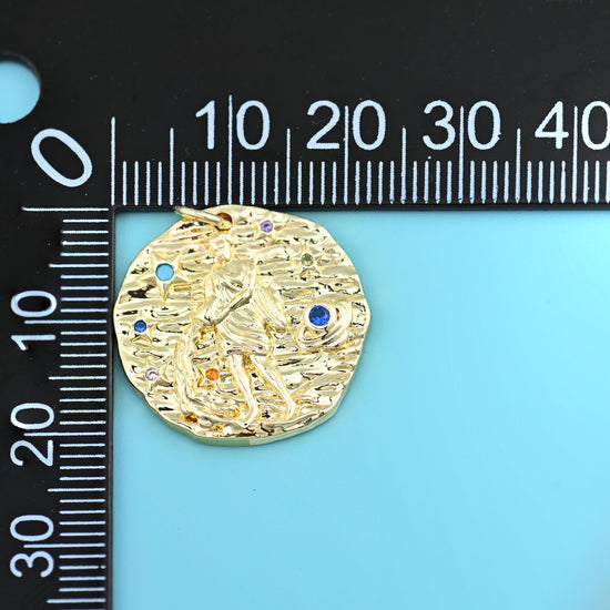 18K gold plated zodiac pendant beside a millimetre ruler, disc measuring about 21mm across