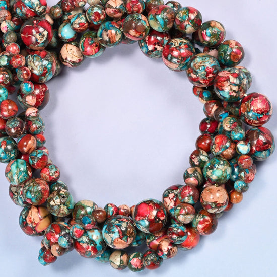Red sea sediment jasper smooth round beads coiled into a densely packed ring with a small opening.