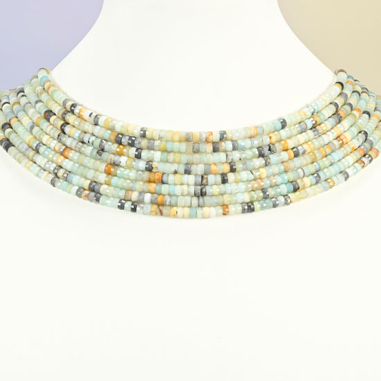 Multi-color amazonite faceted heishi disc strands arranged as a layered collar on a white display bust, blue-green and cream beads across the neck