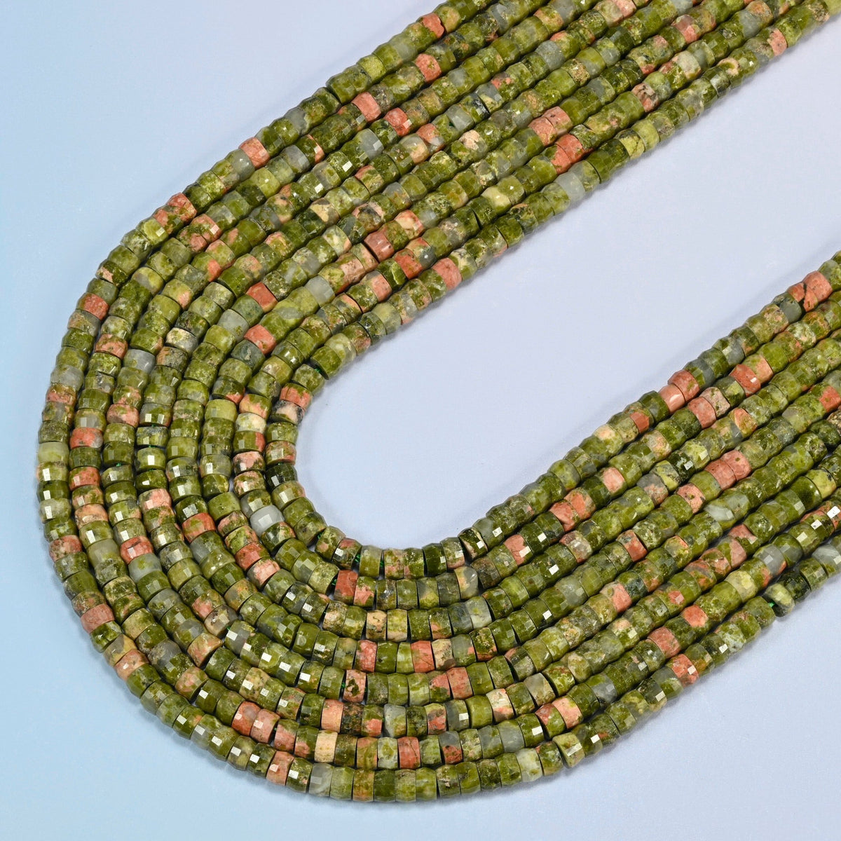 Unakite faceted heishi disc beads in several strands curved into a wide U, olive green stone with pink patches