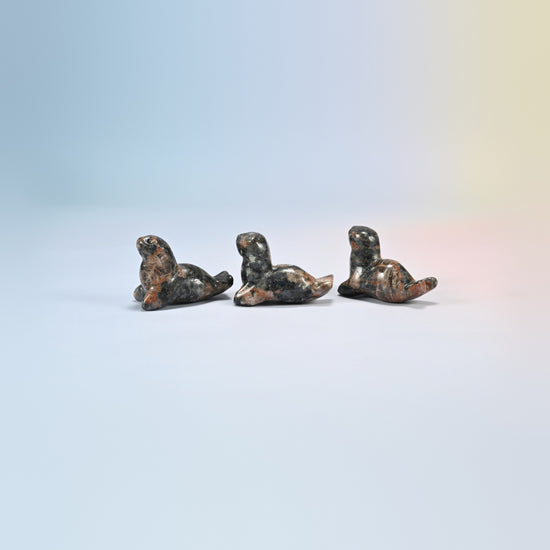 Three red labradorite sea lion crystal carvings, 1.5 inch, black natural stone with orange patches