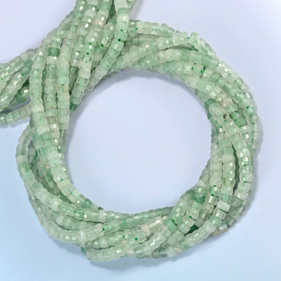 Green strawberry quartz faceted heishi disc beads coiled into overlapping loops, whole strands of light green quartz