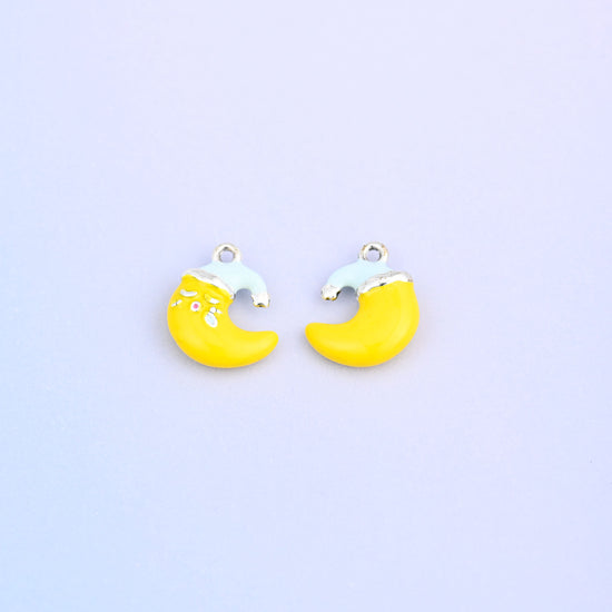 Yellow crescent moon charm in a light blue Santa hat, front and back.