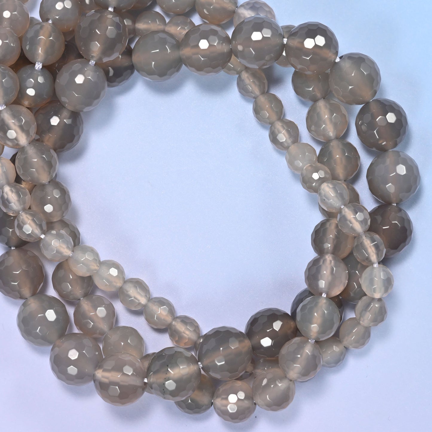 Close-up of gray agate round beads, showing the faceted finish and natural gray tone.
