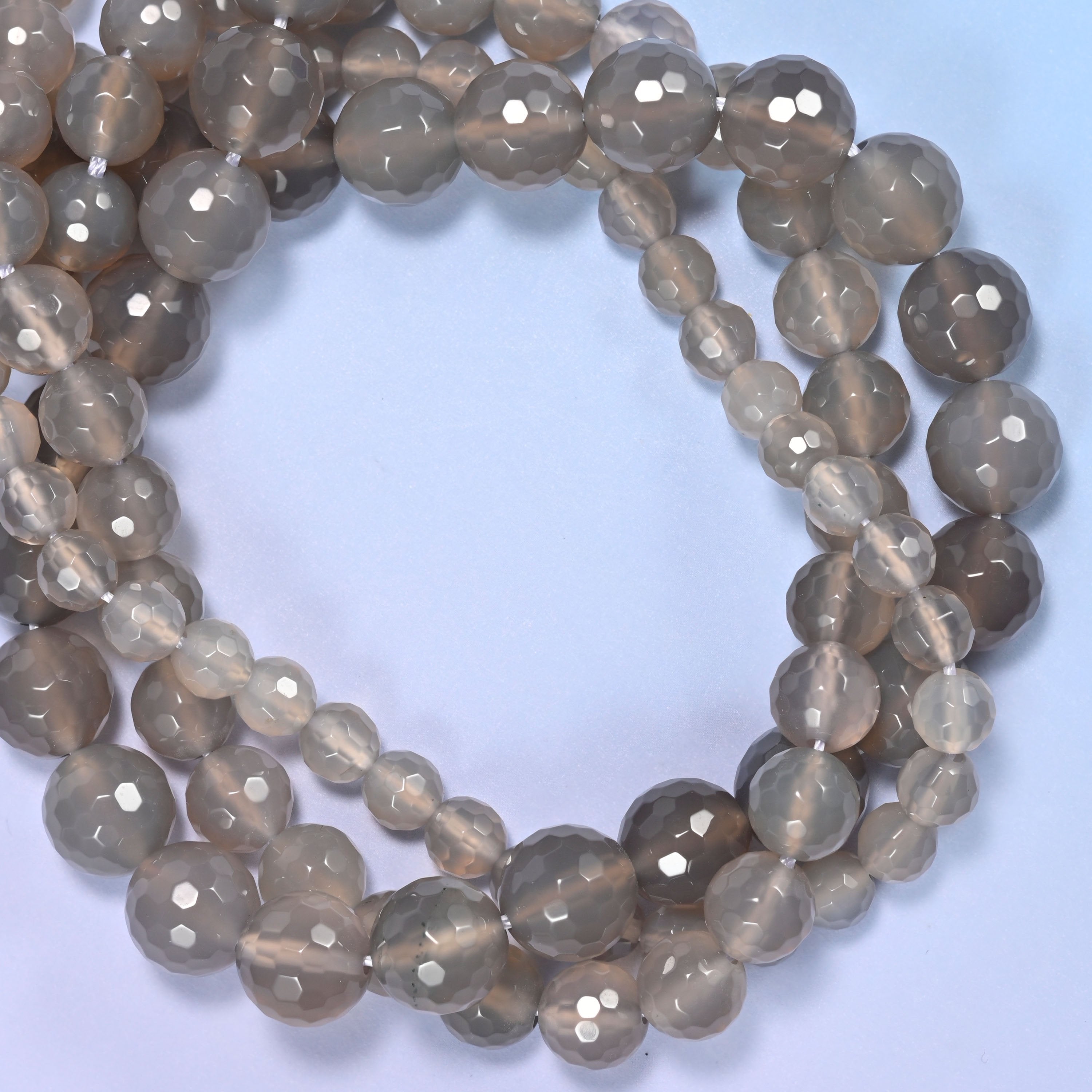 Close-up of gray agate round beads, showing the faceted finish and natural gray tone.