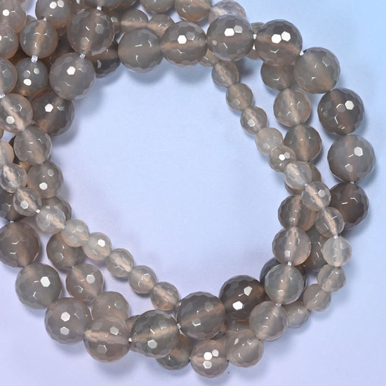 Close-up of gray agate round beads, showing the faceted finish and natural gray tone.