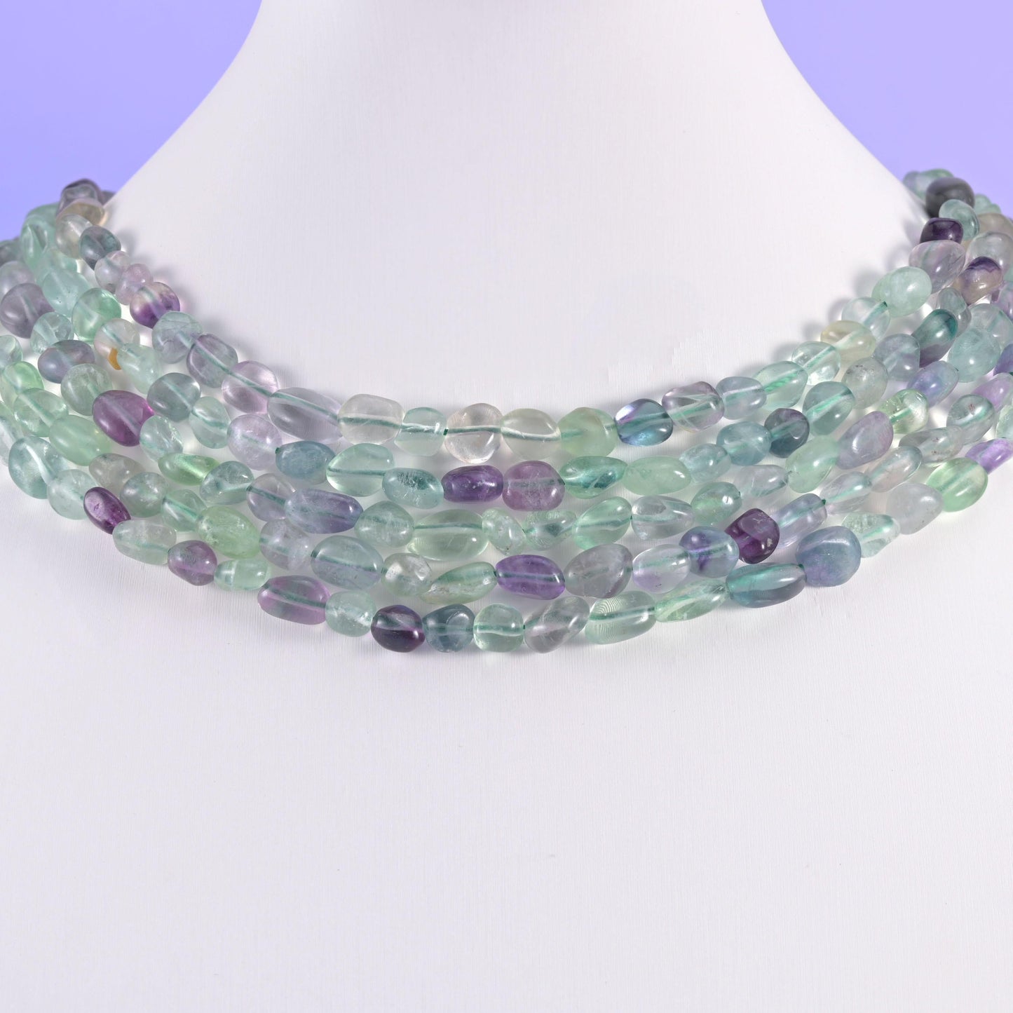 Fluorite pebble beads on a white display bust, worn as a layered collar