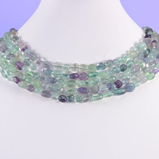 Fluorite pebble beads on a white display bust, worn as a layered collar