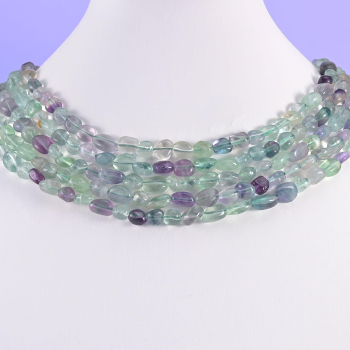 Fluorite pebble beads on a white display bust, worn as a layered collar
