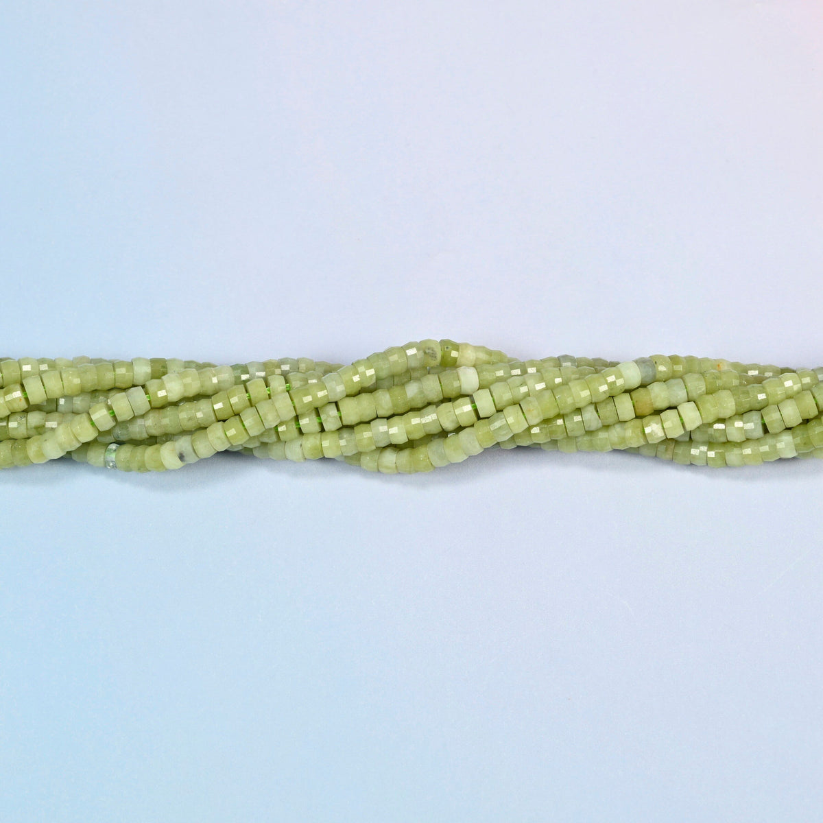 Strands of South Jade faceted heishi disc beads twisted together in a horizontal row