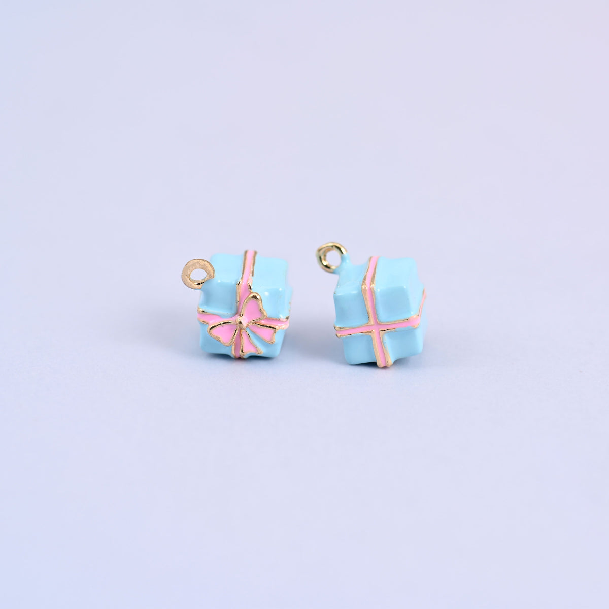 Two light blue gift box charms with pink enamel ribbon and bow.