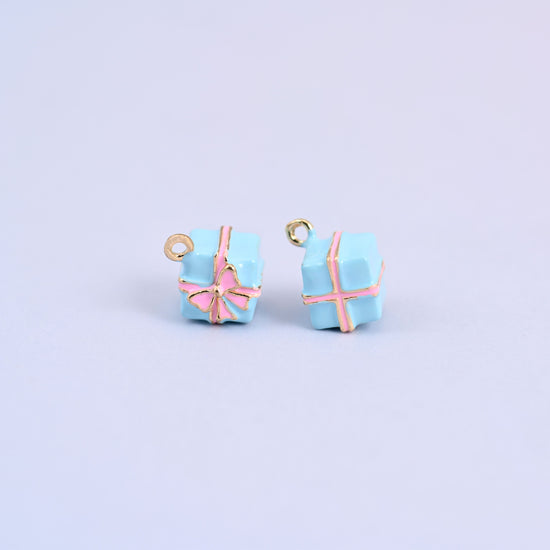 Two light blue gift box charms with pink enamel ribbon and bow.