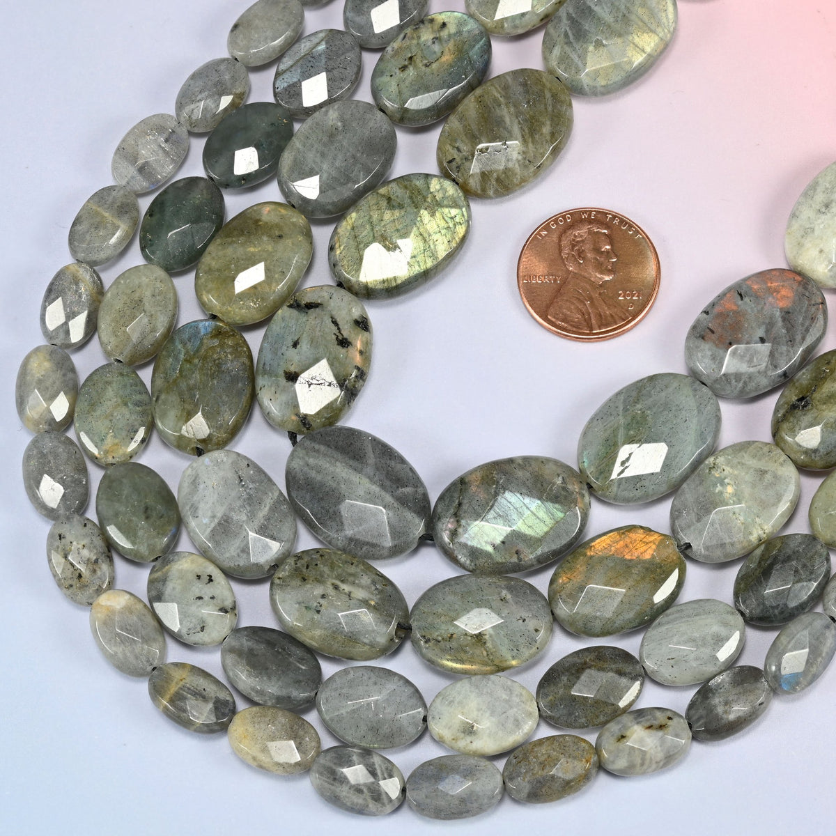 Gray Labradorite faceted oval beads in a deep loop, shown at their true size of 8x12mm to 15x20mm
