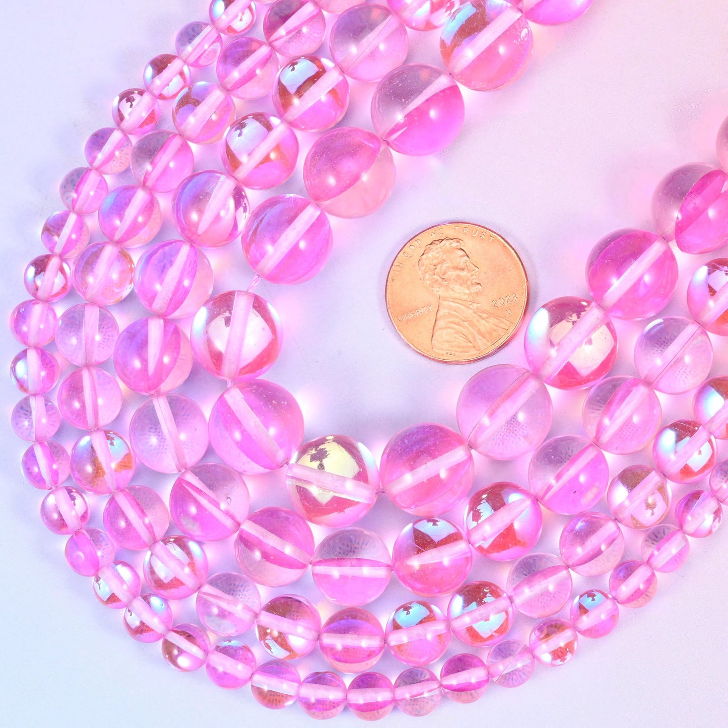Round iridescent pink glass beads with mirrored aura coating