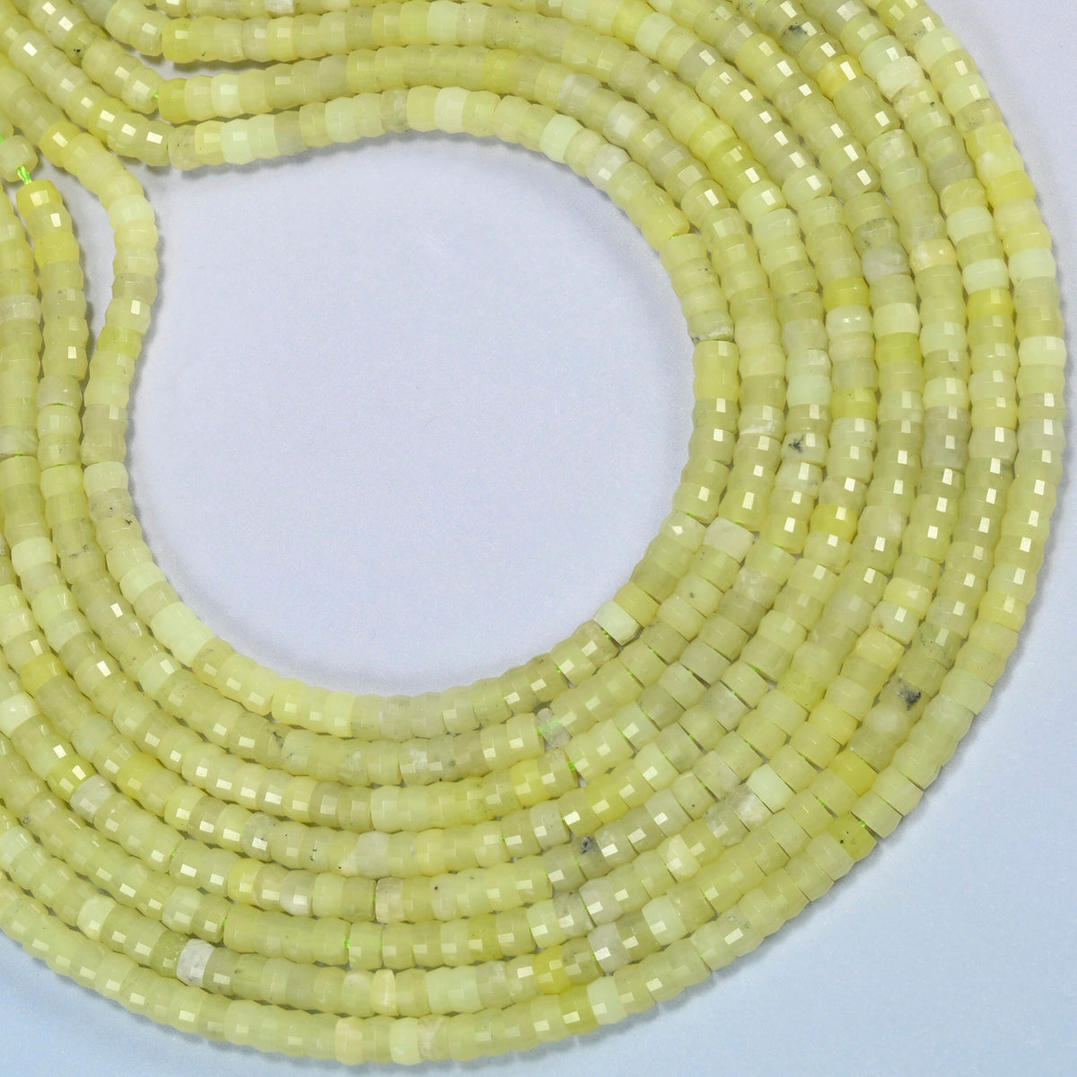 Lemon Jade faceted heishi disc beads curved into an open loop, light yellow-green beads
