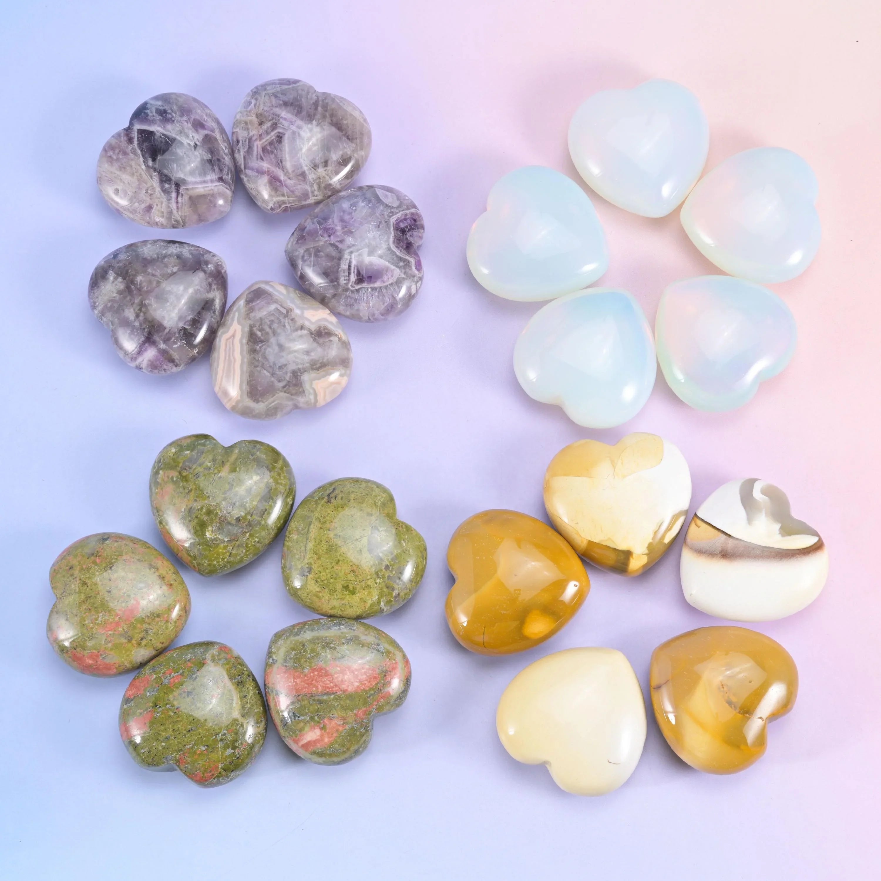Grey and cream hearts beside pale blue glass ones, with unakite and golden tiger eye completing the group