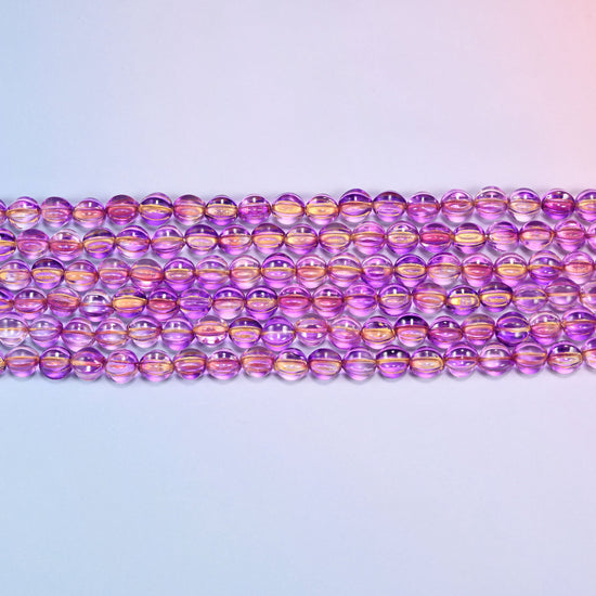 Close-up of 8mm purple gold pumpkin glass beads in four horizontal rows, showing the carved melon ribs.