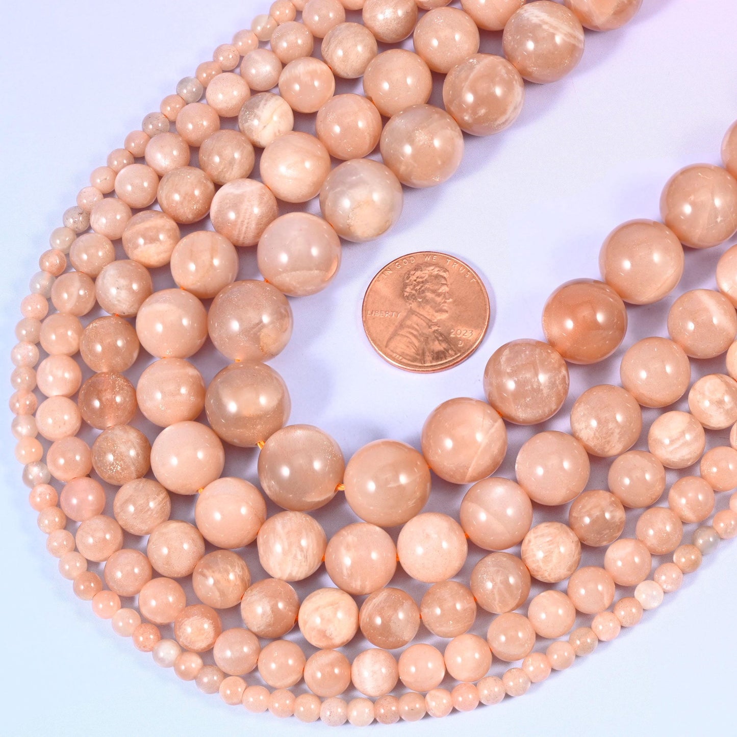 Smooth polished round cut peach moonstone beads for jewelry making.