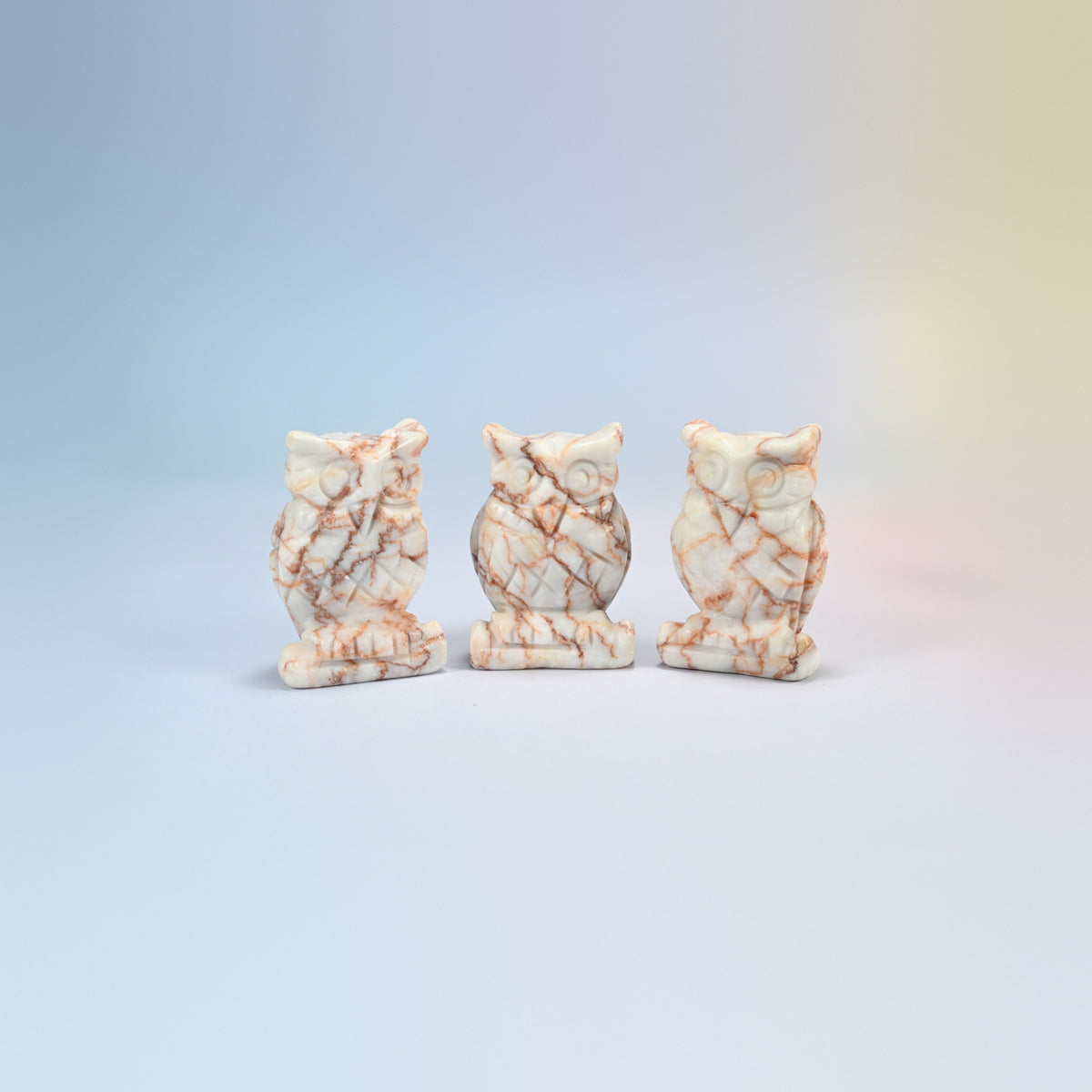Owl crystal carving in red web jasper, cream natural stone with red web veining