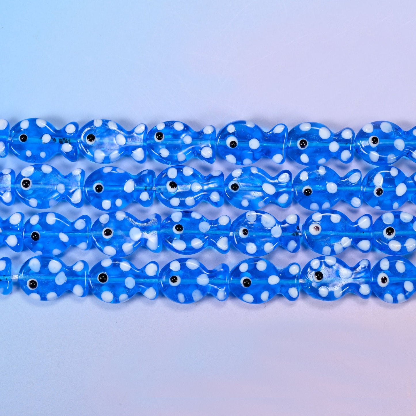 Translucent cornflower blue fish glass beads scattered with opaque white dots