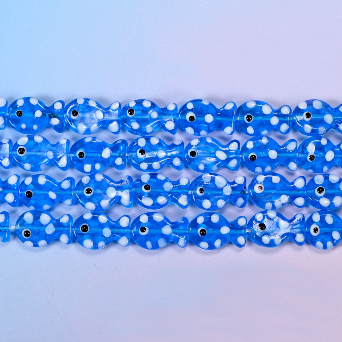 Translucent cornflower blue fish glass beads scattered with opaque white dots