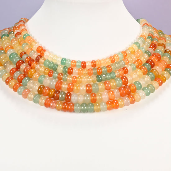 Gold Silk Jade gemstone rondelle beads laid in graduated collar rows, showing 4x6mm and 5x8mm side by side