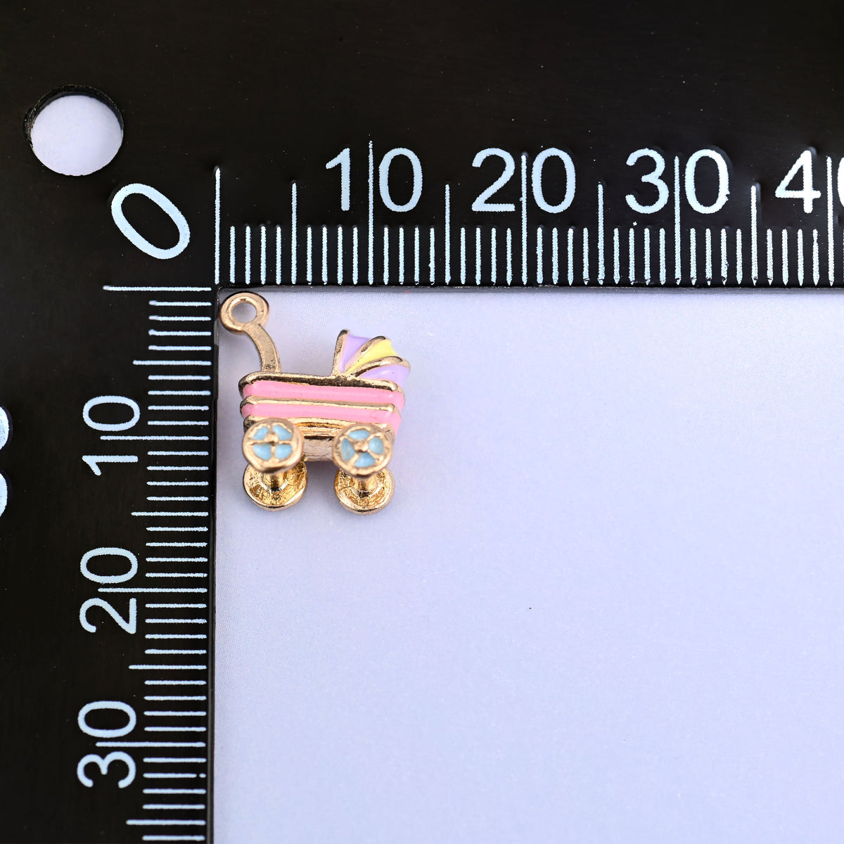 Pink stroller charm measuring 14.57 x 12.7mm, small enough for a bracelet or an earring.