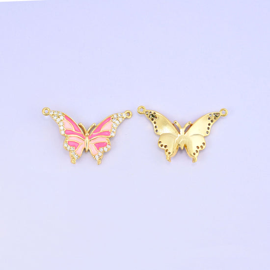 Pink enamel butterfly double connector pendant paired with the reverse of a second charm, showing the smooth gold back and its speckled wing detail.