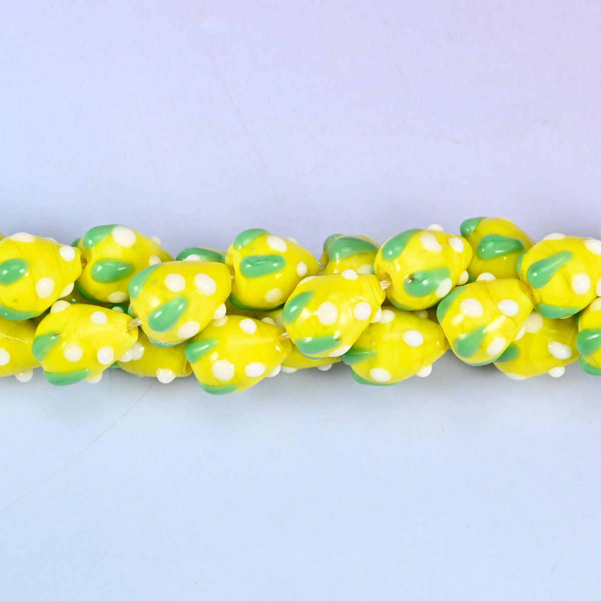 Man-made glass strawberry beads in yellow, white and green