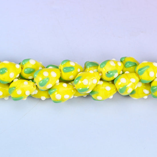 Man-made glass strawberry beads in yellow, white and green