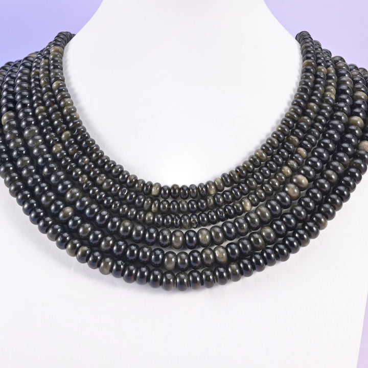 Gold obsidian smooth rondelle beads shown as six close rows on a white necklace display bust.