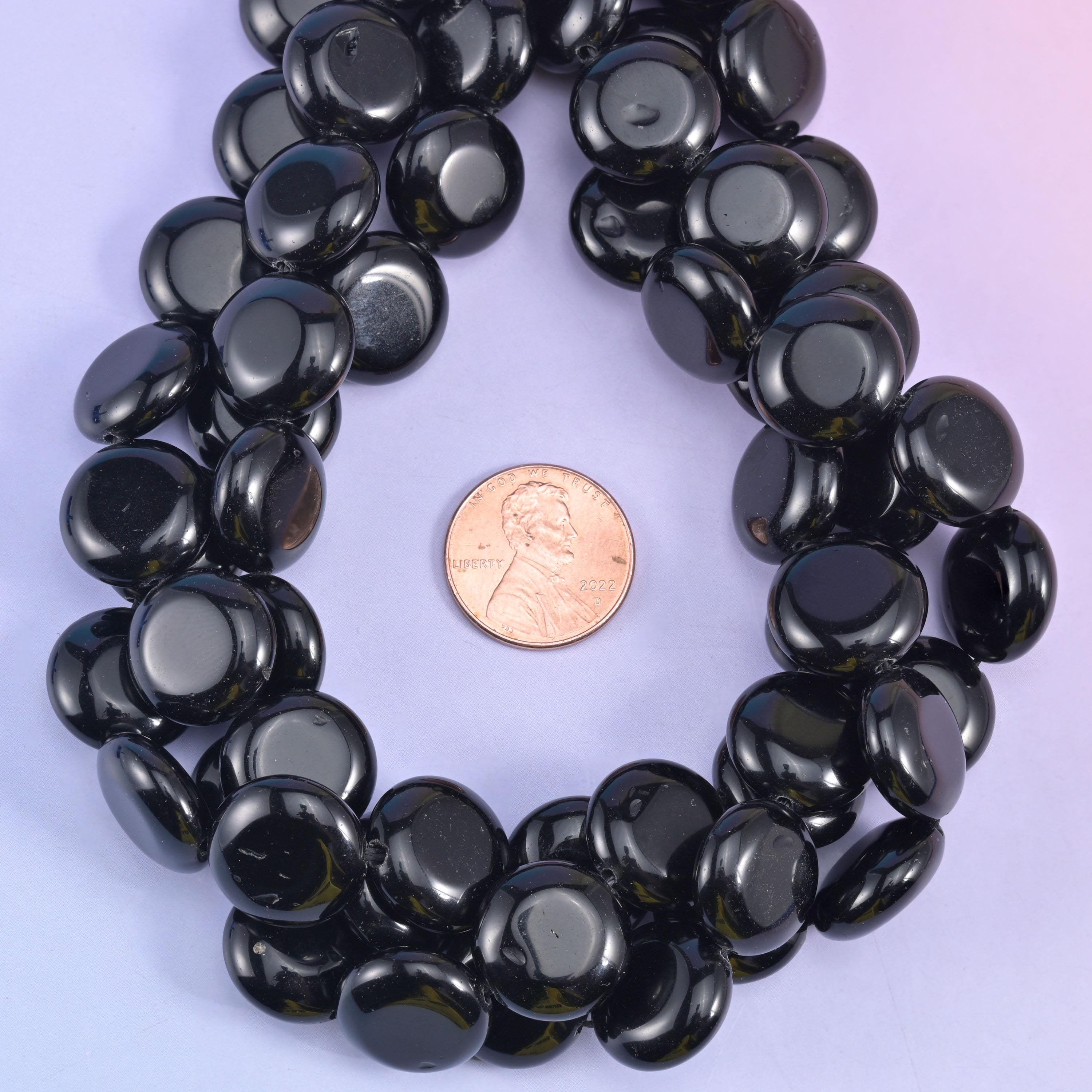 Coin beads circling a penny on lilac, discs evenly matched in diameter around the loop